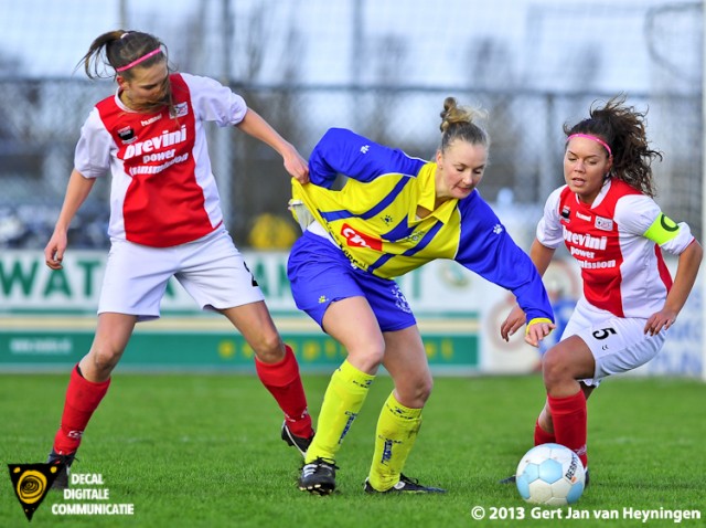 De kwaliteit van het shirtje van Berkel speelster Melissa van den Berg wordt door Lotte Verleng van RCL uitgestest op maximale rekbaarheid. Aanvoerster Stephanie Hartogs van RCL kijkt toe om later in te grijpen.