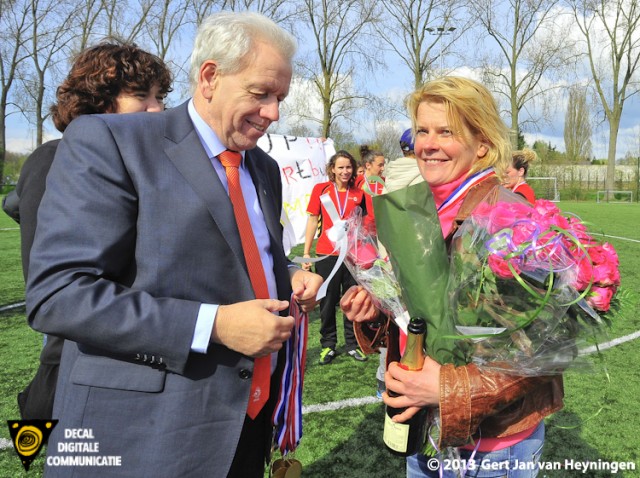 Coach Carola van der Laan ontvangt van Teo Oortman van de KNVB de kampioensmedaille. 